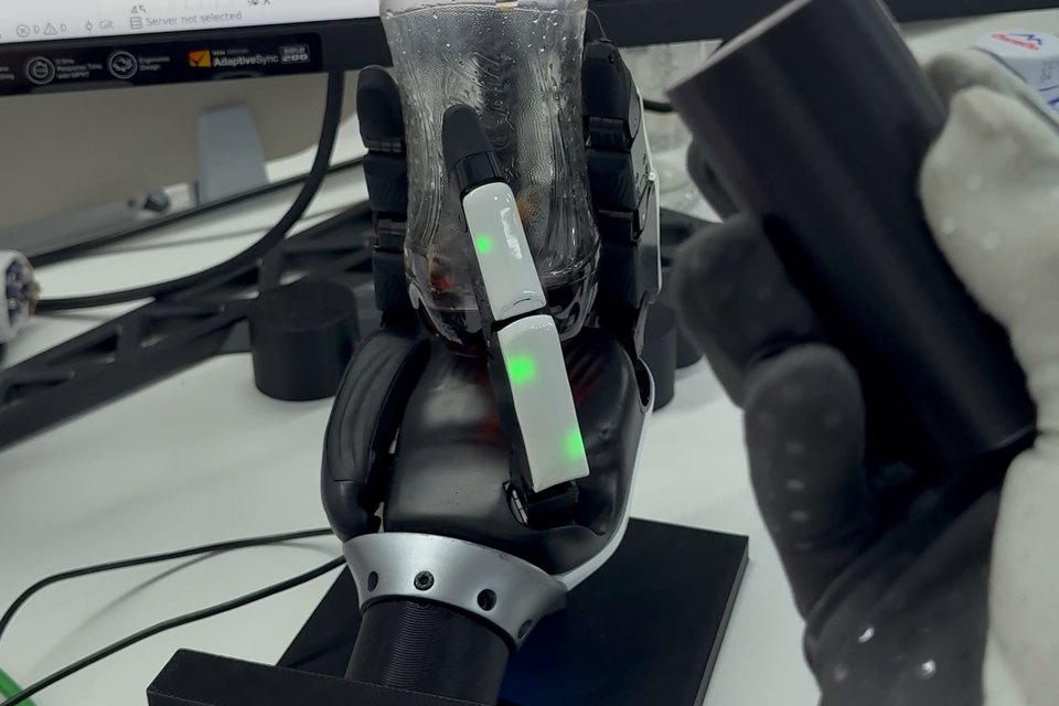 Manus glove guiding the XHand1 Pro to rotate a bottle